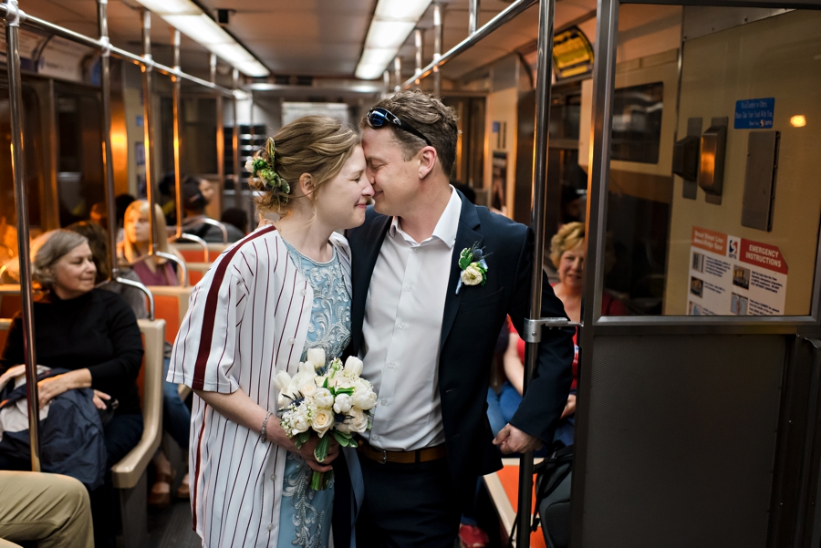 A wedding couple on the Philly subway on the way to their reception at a Phillies game.
